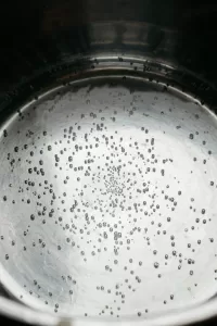 Water with small bubbles beginning to boil
