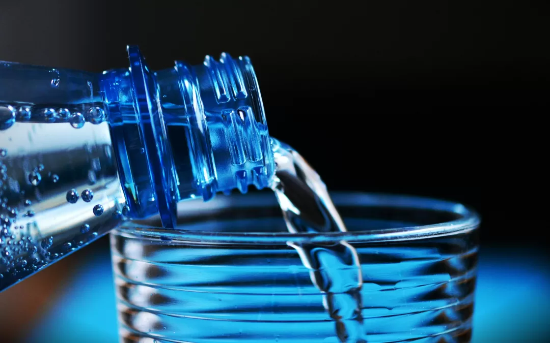 Pouring water from a plastic bottle into a cup