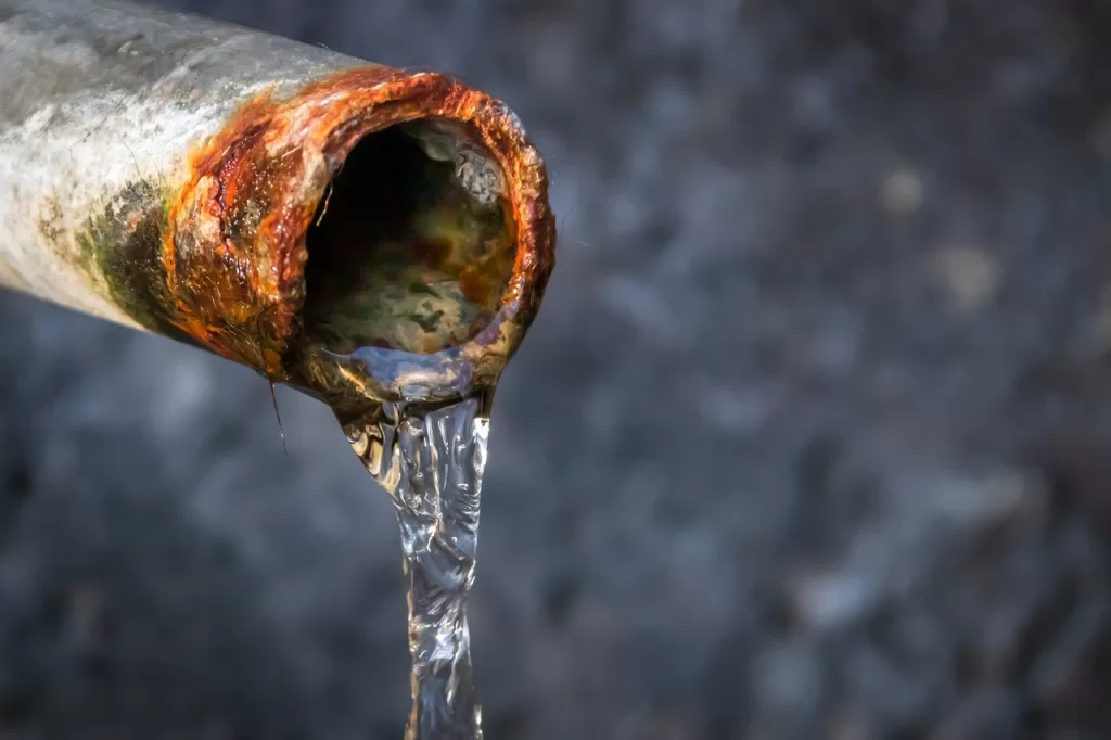 Water trickling from an open, rusting pipe